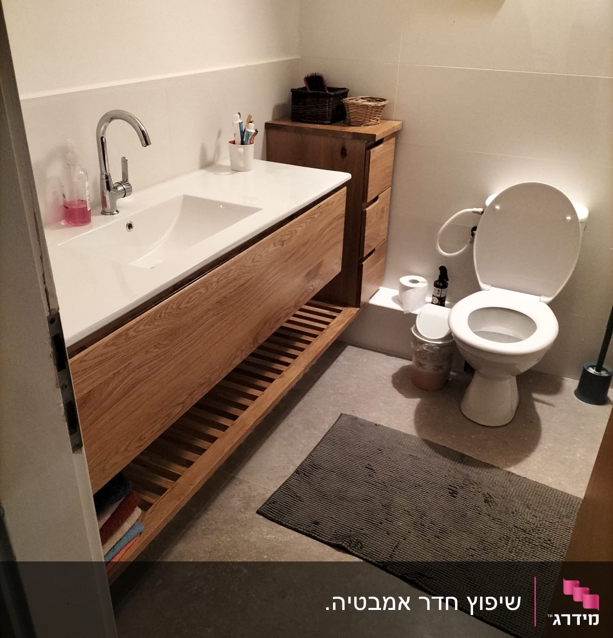 חדר אמבטיה עם כיור עץ וברז מתכת